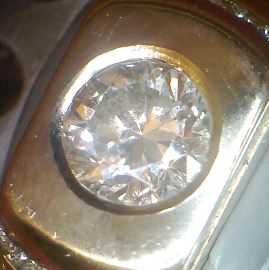 A man's ring with the center diamond in hammered setting