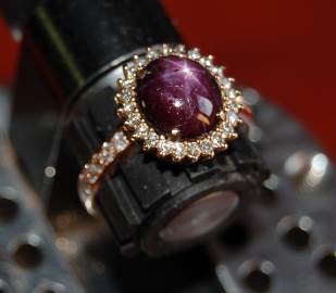A classical style entourage ring with a star ruby centerstone