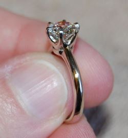 A solitaire engagement ring with a diamond held in six prongs